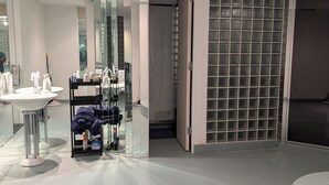 Une salle de bain moderne avec un grand miroir, un lavabo et une douche à parois de verre.