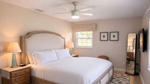 A bedroom with a bed, nightstands, a ceiling fan, a window, and a checkered rug. - Steps to WEC - Geneva Maison @ Swiss Stables on rare 20 acre estate (Ocala)