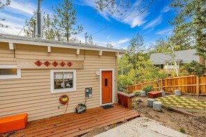 A single-story house with a wooden deck, a mailbox, and a mailbox number sign. - Holiday Chalet Retreat | Lake Views • Fireplace (Fawnskin)