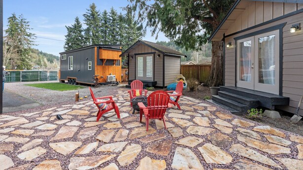 A patio area with stone flooring and red Adirondack chairs. - Cozy Bungalow W/ Lake Access - Near Mt. Rainier (Eatonville)