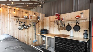 A kitchen with wooden walls, hanging pots, a red mixer, and a black HUSKY storage unit. - Cozy Bungalow W/ Lake Access - Near Mt. Rainier (Eatonville)