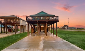 A waterfront property with a covered deck, a staircase, and a view of the water. - Retreat | Gulf Views | Large Deck | Group Ready (Freeport)