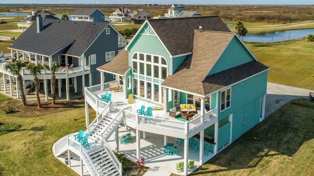 A large house with multiple decks and outdoor seating areas.