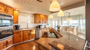 Une cuisine moderne avec des meubles en bois, des appareils en acier inoxydable et un plan de travail en granit.