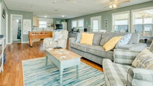 A spacious living area with a sofa, a coffee table, and a ceiling fan. - Dream | Steps to the Beach | Large Deck (Crystal Beach)