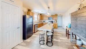 Una cocina moderna con una isla central, armarios de madera y microondas integrado.