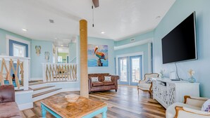 A spacious living room with a wooden coffee table, a brown leather sofa, and a white console table. - Dream | Canal Front | Firepit | Kayking & Fishing (Surfside Beach)