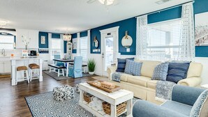 A modern living room with a beige sofa, a coffee table, and a patterned rug.