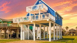 A two-story building with a balcony, a sign reading 'TYKE ON THE BEACH,' and a beachside location.