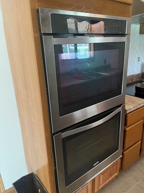 Forno a incasso in legno con pannello di controllo digitale e due vani in acciaio inox.