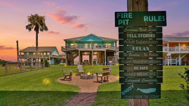 A resort with a fire pit area, outdoor seating, and a sign listing amenities like adult supervision and no gasoline. - Retreat | Steps to Beach | Firepit | Family Fun (Crystal Beach)
