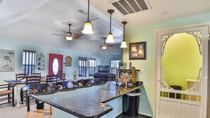 A restaurant interior with a bar area, ceiling fans, and a decorative door. - Retreat | Steps to Beach | Firepit | Family Fun (Crystal Beach)