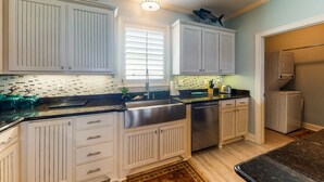 A kitchen with white cabinetry, a stainless steel sink, and a dishwasher.