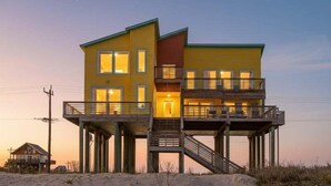 A two-story waterfront house with a balcony and a staircase leading to the upper level. - Beachfront 4br, Hot Tub, Multiple Deck, Sleeps 16 (Gilchrist)