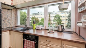 A kitchen with a large window, a dishwasher, and a toaster. - Wild and Free Urban Jungle Apartment (Łódź)