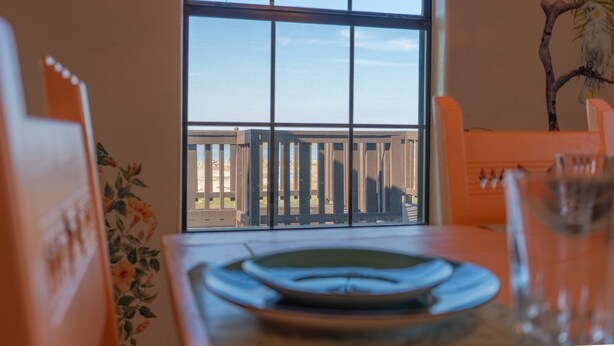 Un espace repas avec vue sur un balcon et une clôture en bois.
