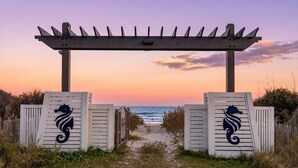 A wooden pergola entrance with a seahorse design, leading to a beach path. - Luxury Ocean View l Pool l Free Cancellation (Crystal Beach)