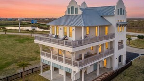 A multi-story house with a balcony, a porch, and a view of the surrounding landscape. - Luxury Ocean View l Pool l Free Cancellation (Crystal Beach)
