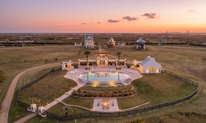 A large estate with a swimming pool, multiple buildings, and a well-maintained lawn.