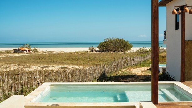A pool area with a view of the beach and ocean.