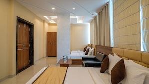 A hotel room with a bed, a sofa, a coffee table, and a wardrobe.