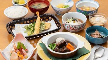 A variety of dishes including seafood, vegetables, and soup, arranged on a wooden table.