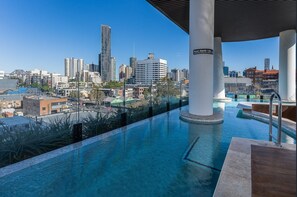 An infinity pool with a city skyline in the background. - Luxe Apartment w/ Balcony & Stunning City Views (Brisbane)