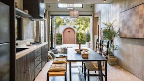 Una cocina moderna con comedor, que cuenta con un amplio ventanal, armarios empotrados y una mesa de comedor con sillas.