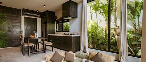 A modern kitchen with dark cabinetry and a dining area with a table and chairs.