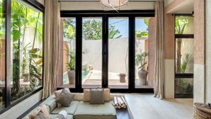 A modern living room with a large sliding glass door leading to an outdoor patio. - Bedouin Loft Pererenan (Canggu)