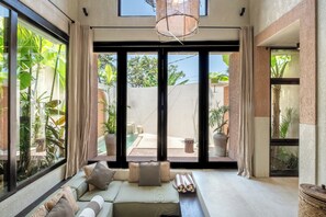 Deluxe Villa, 1 Bedroom, Patio, Pool View | Living area | 55-inch TV with cable channels