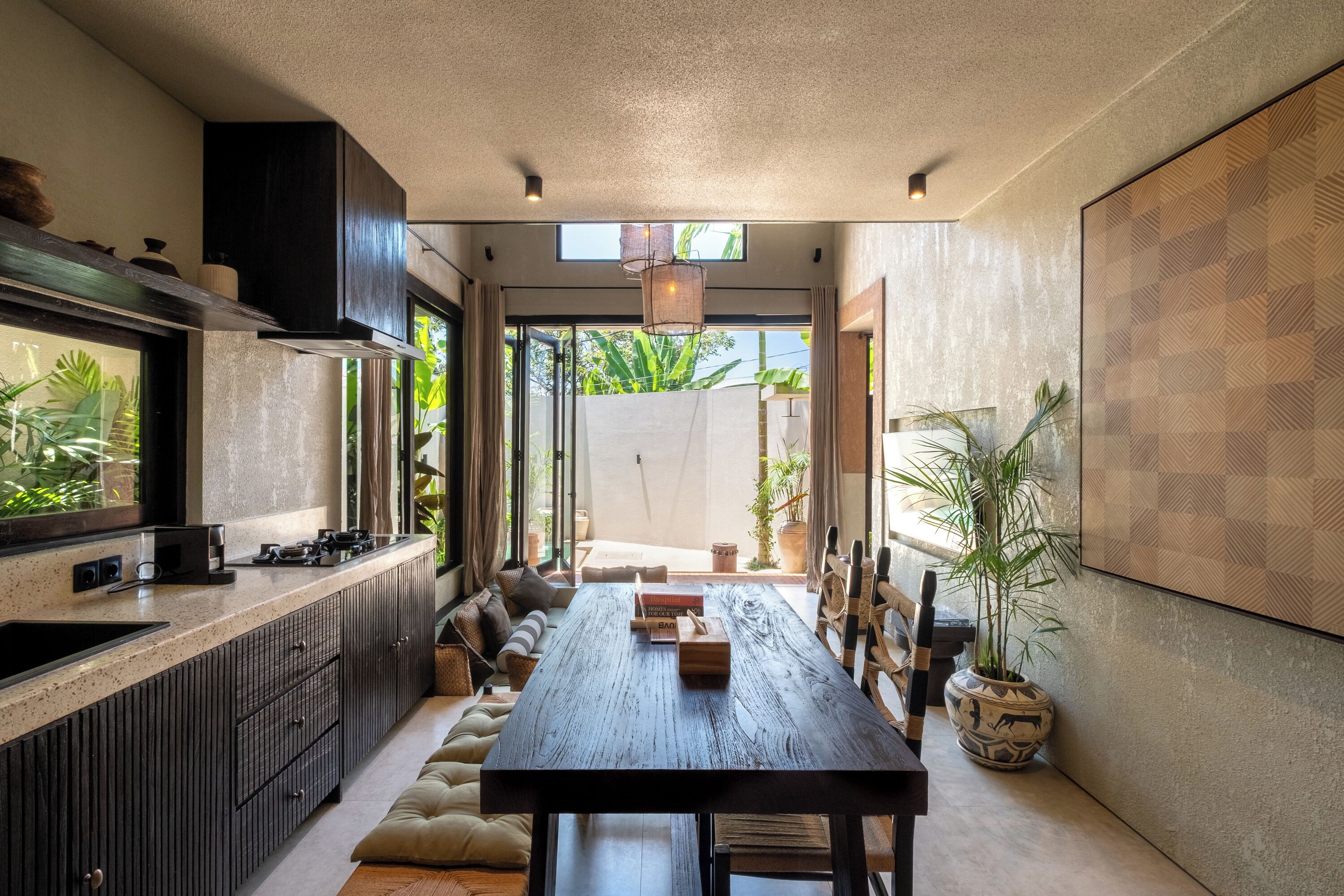 Una cocina moderna con una isla central, armarios empotrados y un amplio ventanal que proporciona luz natural.