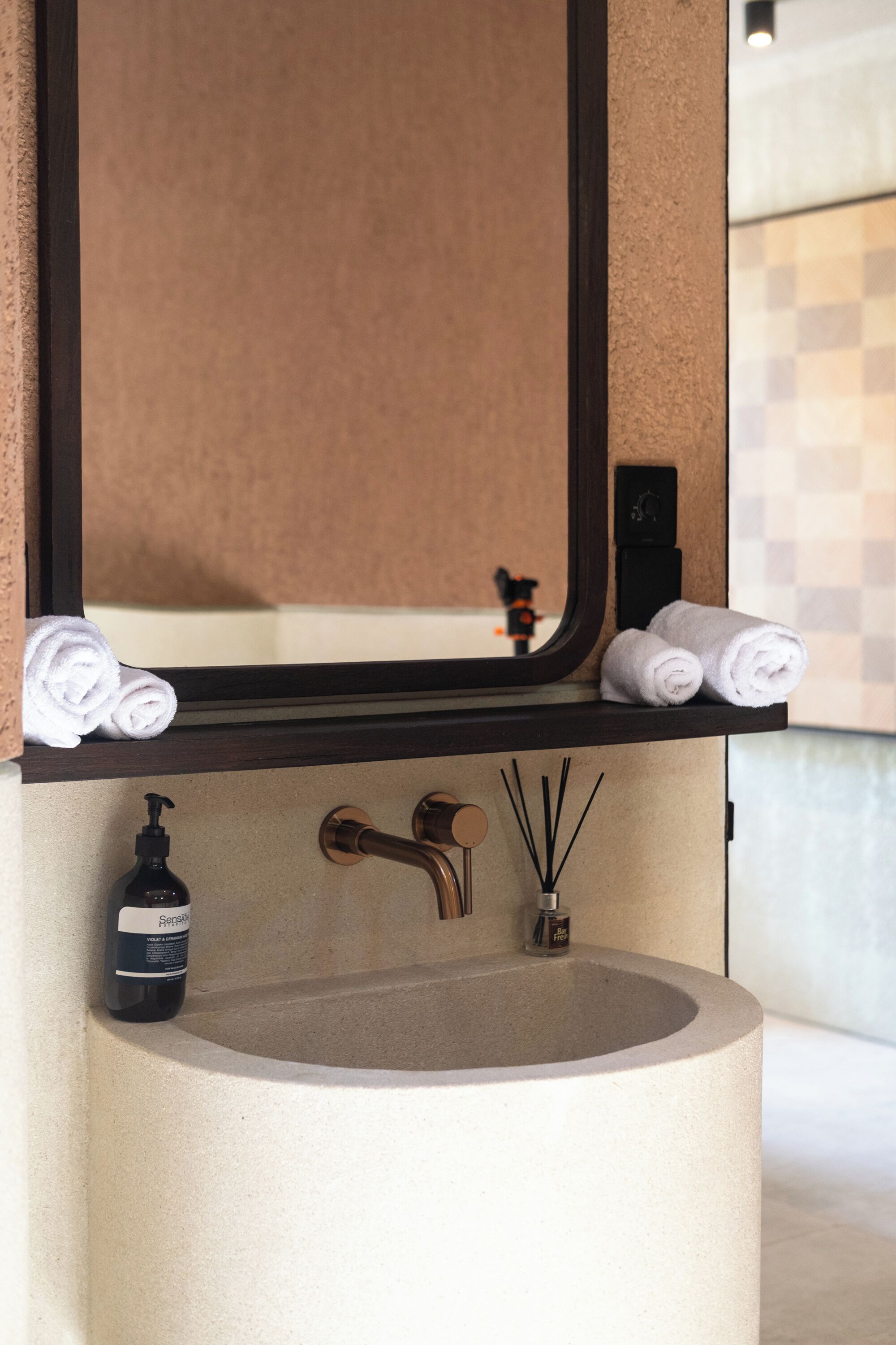 A bathroom with a large mirror, a round sink, and a towel rack.
