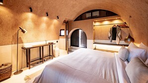 A bedroom with a large bed, a bedside table, a mirror, and a wardrobe. - Bedouin Loft Pererenan (Canggu)