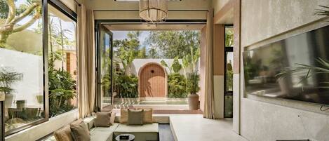 Villa de lujo, 1 habitación, patio, vistas a la piscina | Zona de estar | Televisión de 55 pulgadas con canales por cable