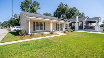 A two-story house with a front porch, a garage, and a well-maintained lawn.