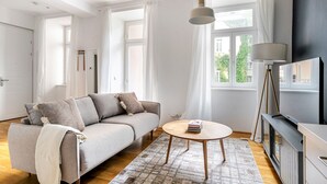 A modern living room with a sofa, a coffee table, and a TV stand.