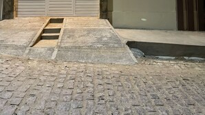 A building with a stone facade and a closed garage door. - Pousada Santo Mel (São Tomé)