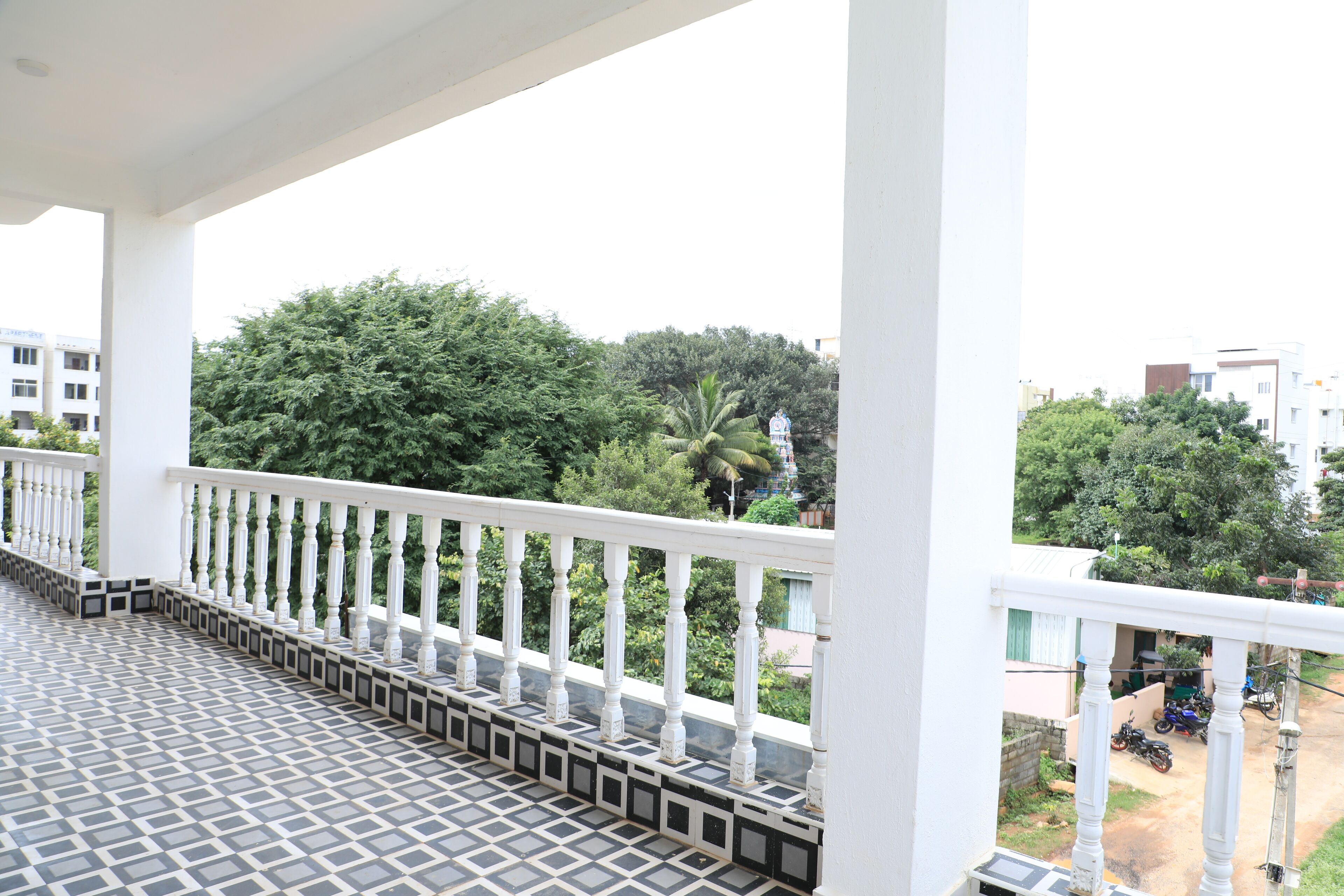 A balcony with a tiled floor and white balustrade.