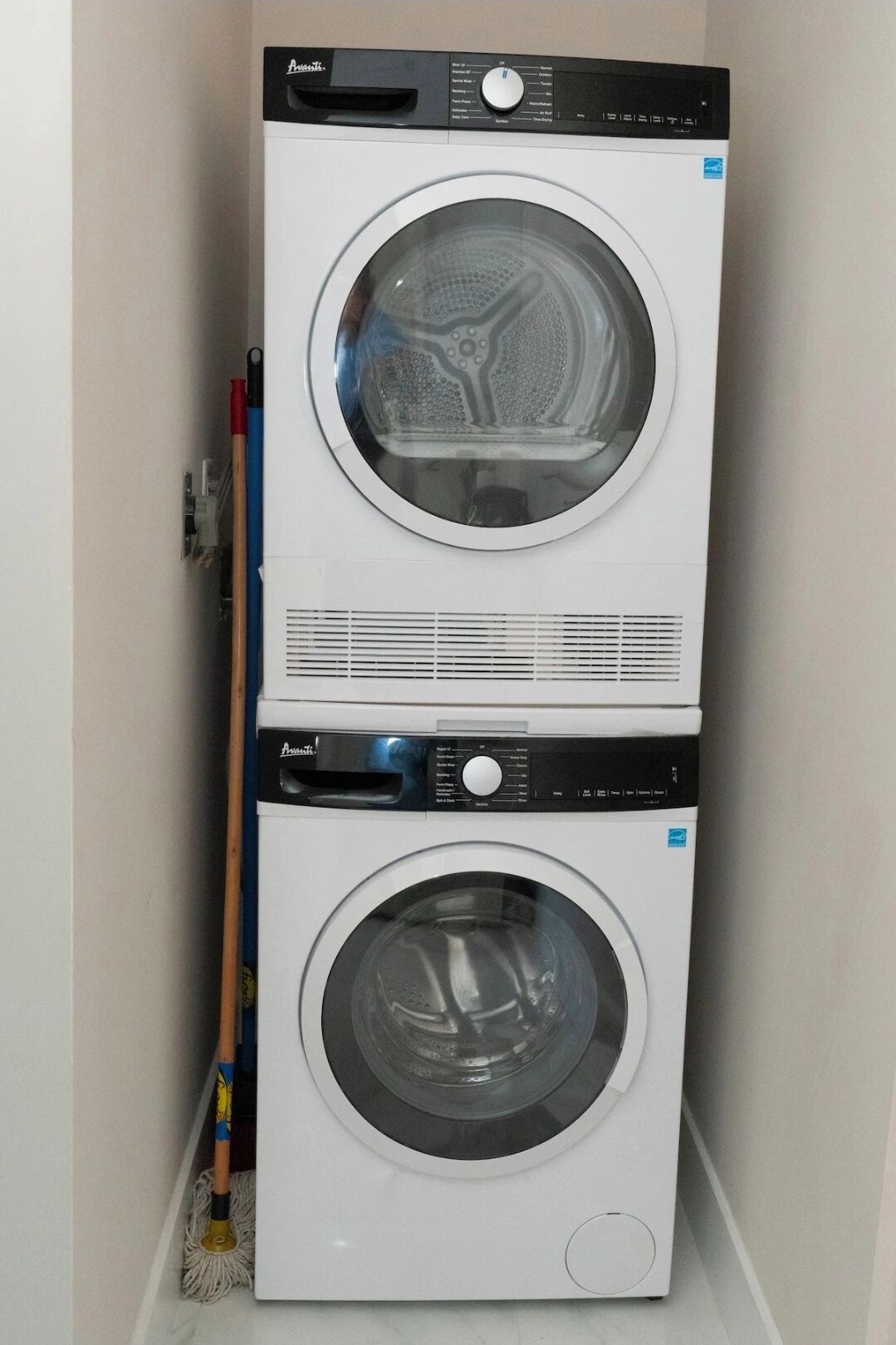 Une machine à laver et un sèche-linge superposés dans une buanderie.