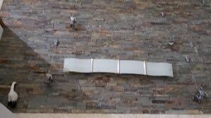 Une pièce avec un mur en pierre et un plafond en bois.
