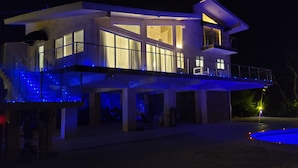 Une maison moderne à deux étages, dotée d’un balcon et d’une piscine.