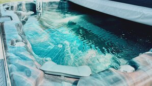 Ein Whirlpool mit integriertem Sitz und einer Holzterrasse.