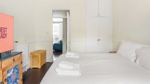 Ett hotellrum med en säng, en byrå i trä, en tv och en garderob.