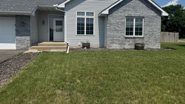A two-story house with a garage, a front porch, and a well-maintained lawn. - Superb 5-bedroom house in Big Lake in friendly, safe neighborhood. (Big Lake)