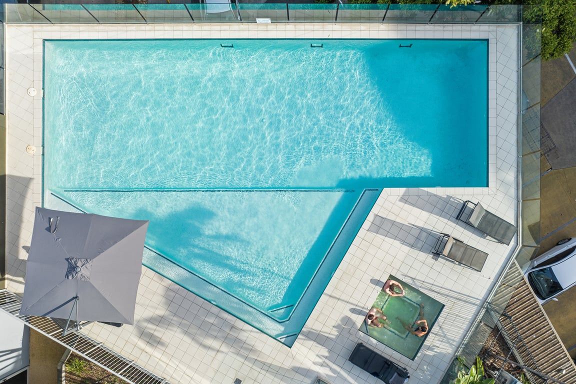 Una piscina rectangular con un bordeado de baldosas.