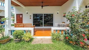 A covered patio with a ceiling fan, wooden benches, and potted plants. - IslandHideaway Near Promthep Sunset V205 (Rawai)