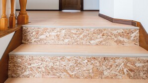 Un escalier avec des balustrades en bois et une porte en bois en haut.