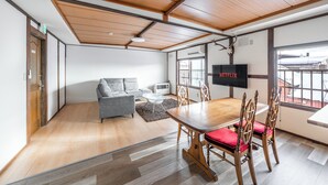 Une salle de réunion moderne équipée d’une table en bois, de chaises, d’un canapé et d’un écran de télévision.