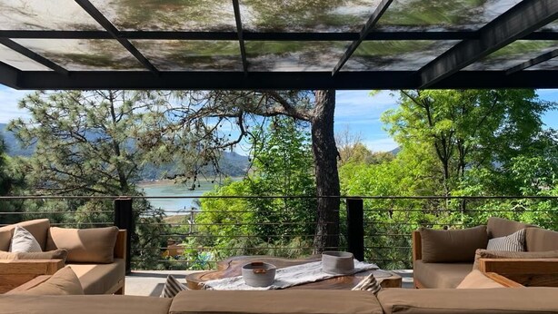 Un área de estar al aire libre con vistas a un lago y árboles.
